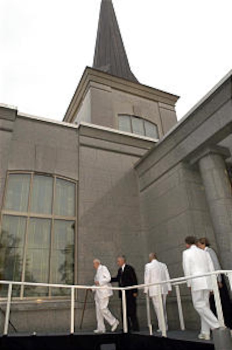 President Gordon B. Hinckley , followed by Elder Richard G. Scott and Elder Bruce C. Hafen, emerges