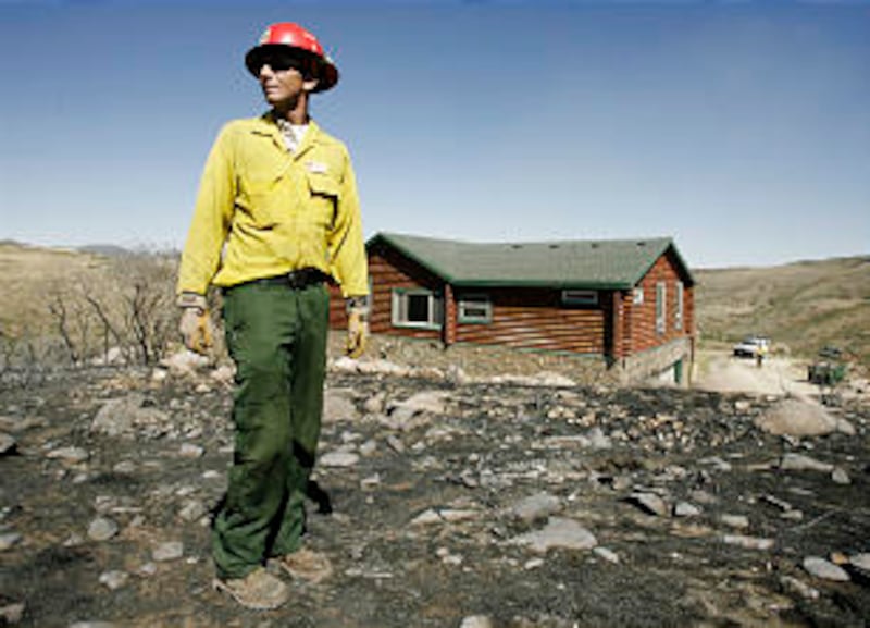 Fire crew public information officer Jason Curry looks over fire damage near homes in Rose Canyon ne