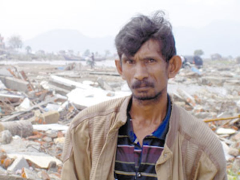 A man walking through tsunami rubble in Indonesia lost his entire family, including his wife, childr