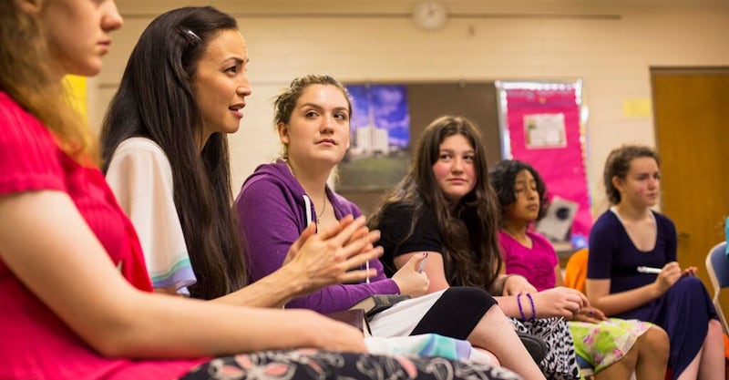 A young women class counsels together.