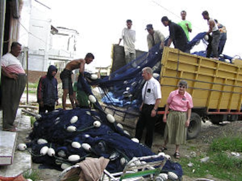 Church-service missionaries Bill and Linda Hamm oversee unloading of fishing nets as part of Church'