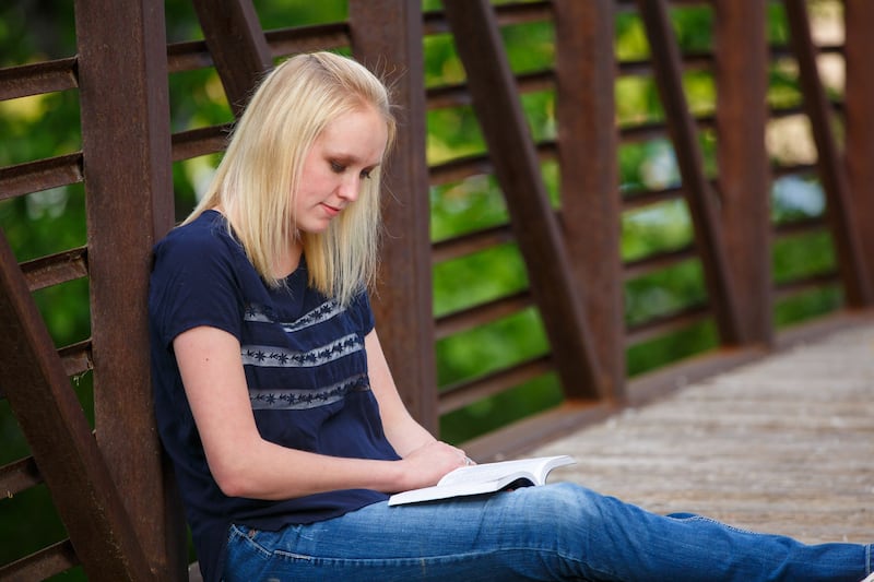 A young woman reads scriptures.