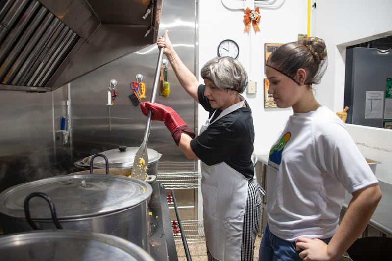President Emily Belle Freeman stirs a big pot during a community service activity in Naguabo, Puerto Rico, on Saturday, May 16, 2026.