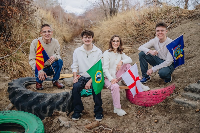 Four Stoddard siblings who have been called as missionaries hold the state and country flags for their mission assignments in Lehi, Utah, Feb. 15, 2026.