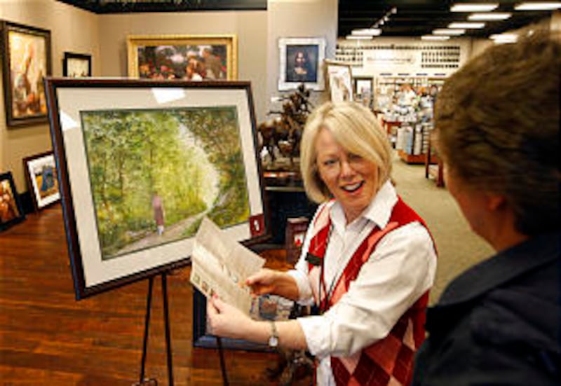 Linda Howard, art concierge for Deseret Book, helps a customer with the self-guided tour of painting