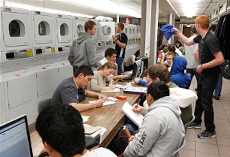 Missionaries study while doing their laundry.