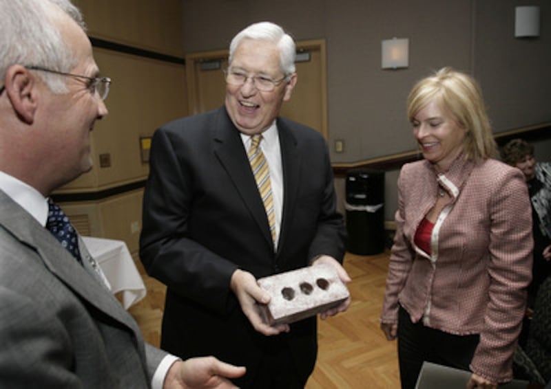 LDS Church Presiding Bishop H. David Burton (center) receives a brick from the original Primary Chil