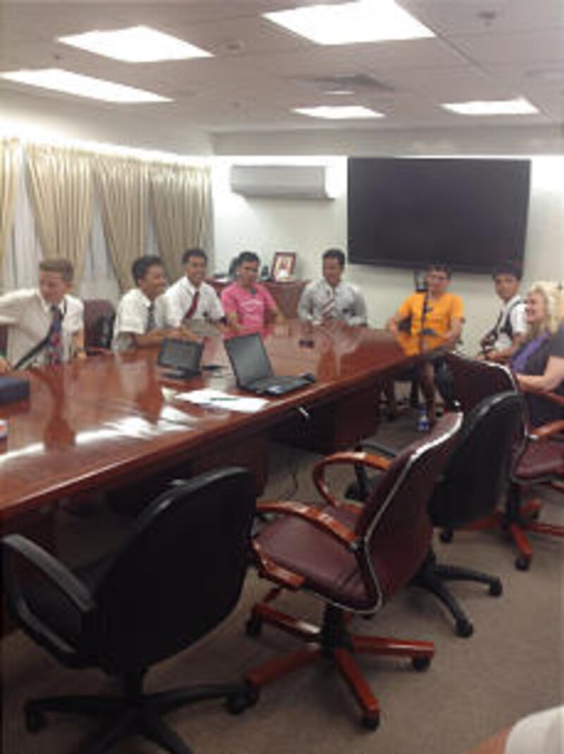 Elder Kyle Marlin of Star, Idaho, orange shirt, and Elder Norman Disbarro, sitting at Elder Marlin's