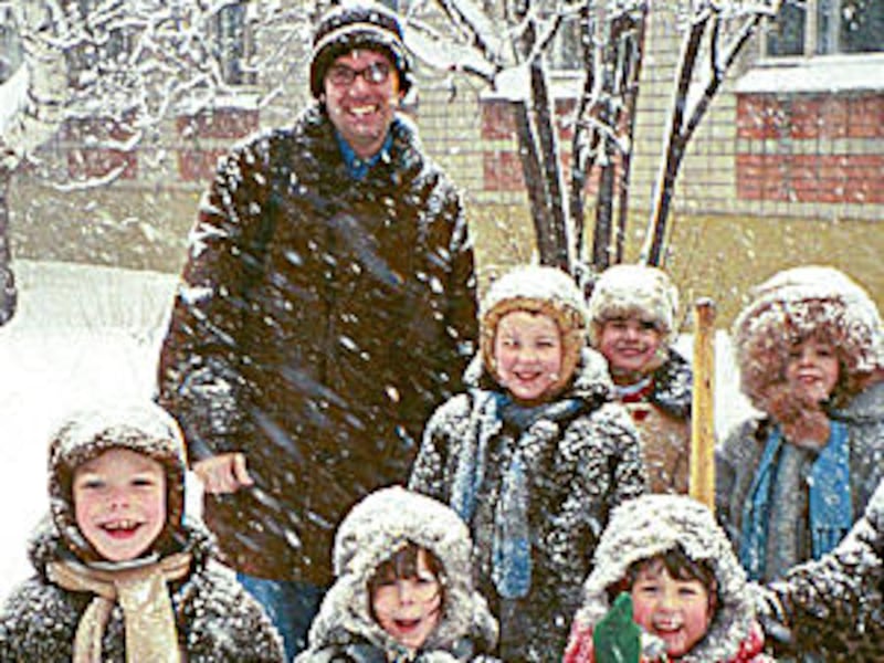 Tyson Bauer stands with children at orphanage in December 2000. The charitable organization he began