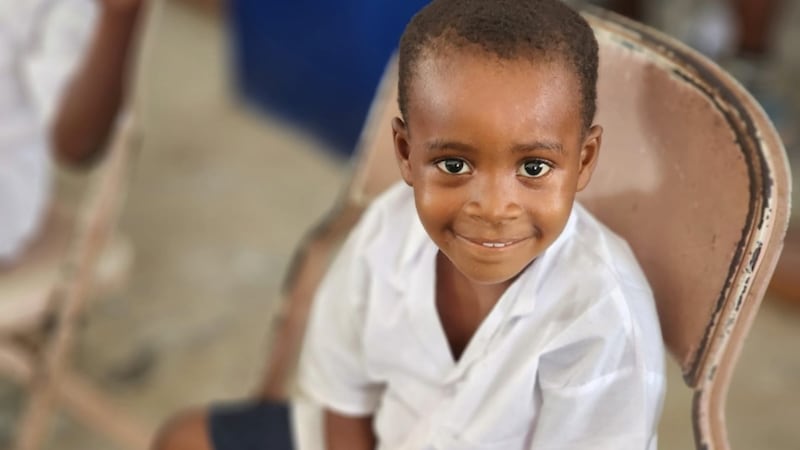 A child smiles during the ceremony marking the donation of new classrooms and supplies at an elementary school in Lower Margibi County, Liberia, Feb. 21 2026.