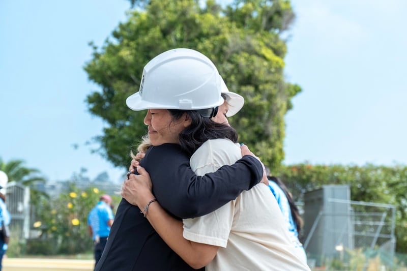 Volunteers hug during a Habitat for Humanity effort to rebuild homes destroyed during the Palisades Fire during a four day event in September 2026 in Los Angeles, California.