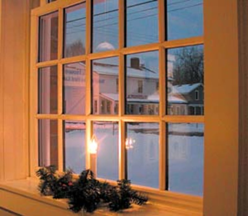Candle glows in window of Johnson Inn in view of the Whitney store.