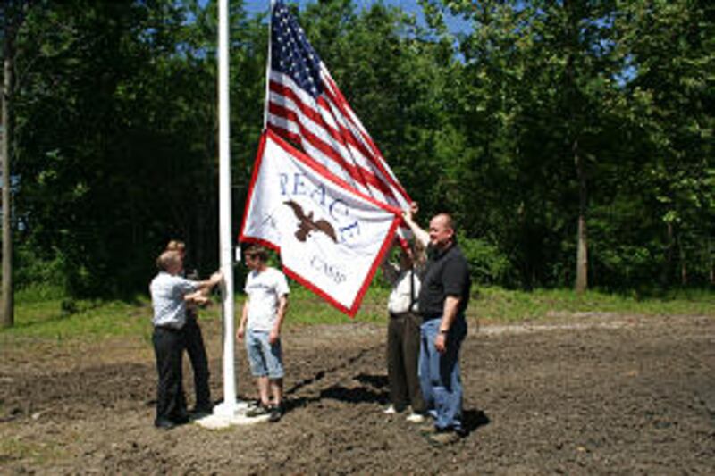 A replica of the Zion's Camp flag, made by Pearl Thompson, was raised along with the U.S. flag on a