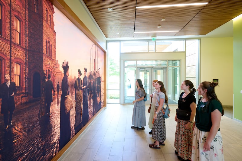 Sister missionaries look at a mural depicting the first single sister missionaries of this dispensation, at the Provo Missionary Training Center in Provo, Utah, June 19, 2026.