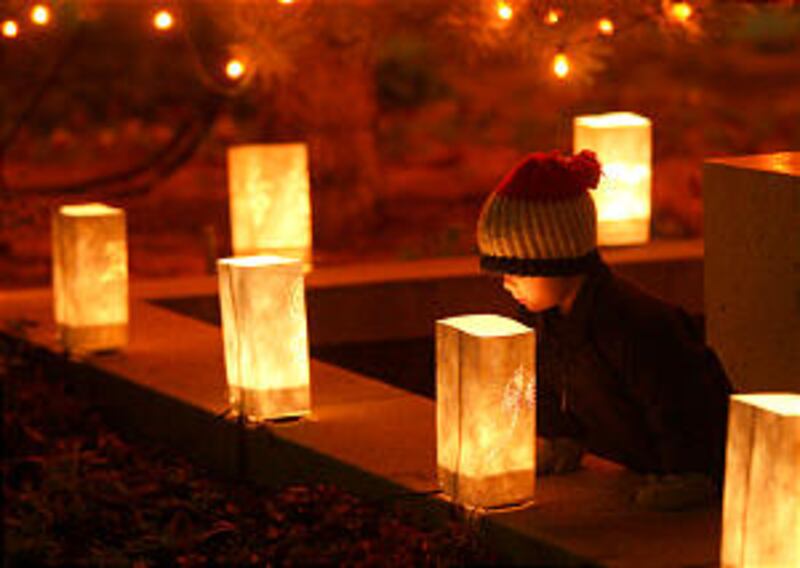 Three-year-old Jacob Scheffner peeks inside a luminary outside the Church Office Building as he and