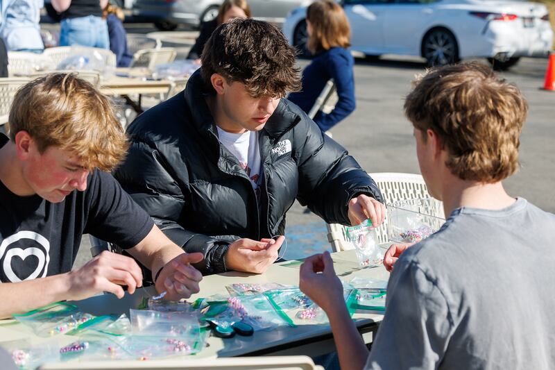 Three high school boys assemble bracelets during a service project in Meridian, Idaho, Friday, Feb. 27, 2026.