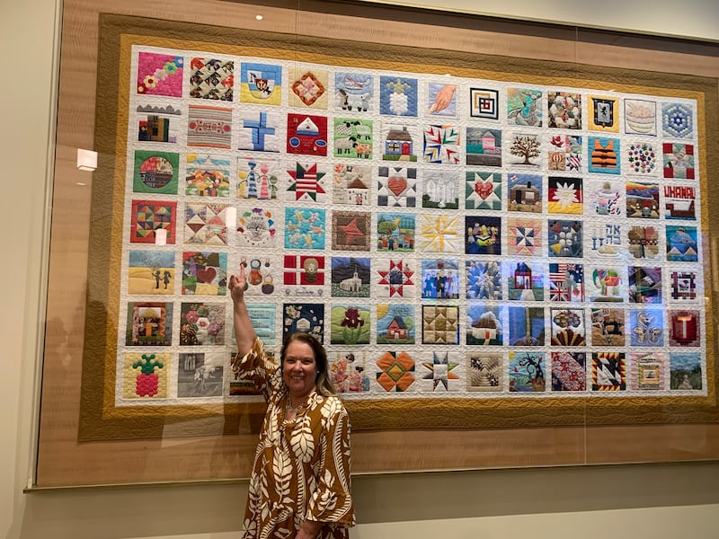 Gabriela Vega points to her quilt block in "The Family Quilt" during a visit from Uruguay to the Temple Square Visitors' Center in Salt Lake City on June 29, 2026.