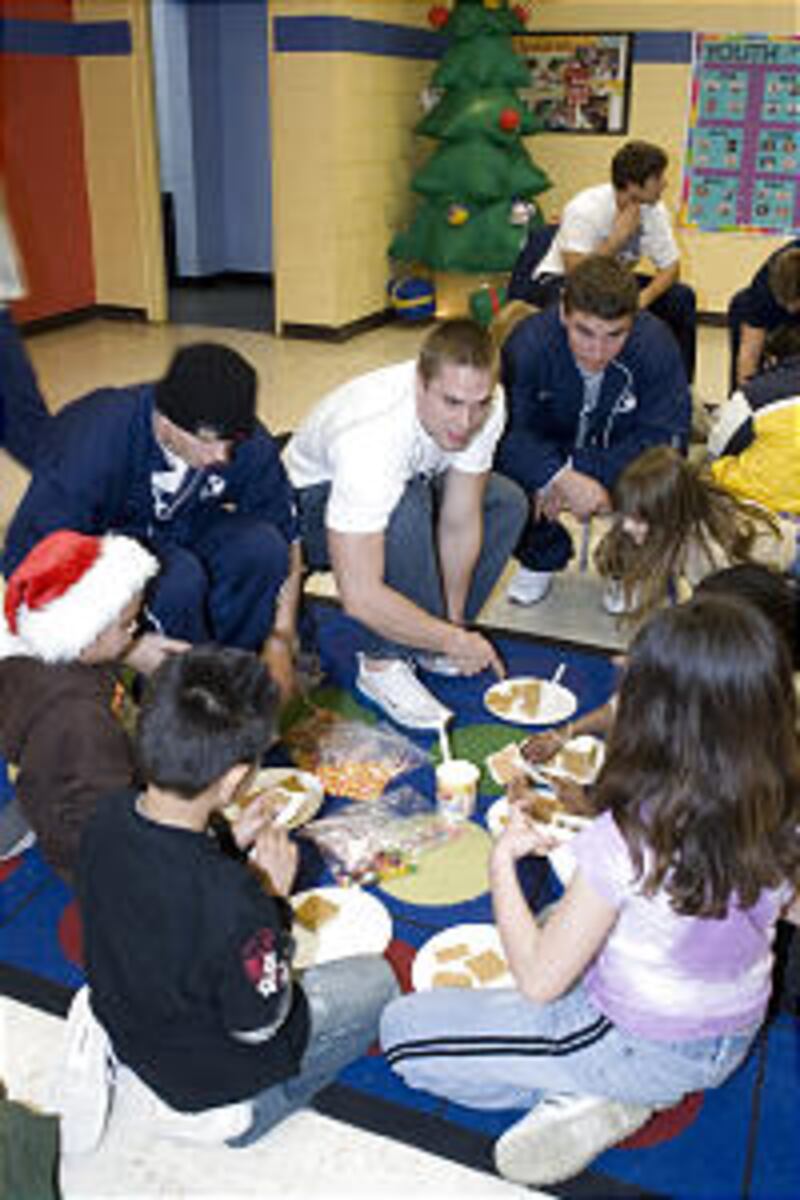 Ryan Neeley, Kellen Fowler, Robert Ramos helps make a gingerbread house during a service project at