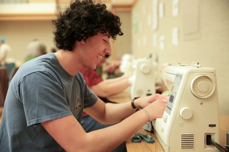 Ezekiel Weber helps sew sleep masks as part of a service effort on May 23, 2026, in Montreal, Quebec.