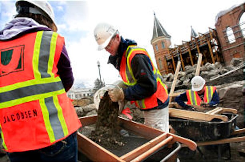 Scott Ure,center, dumps a bucket of dirt onto Michaela Miller's screen to be sifted. Students from B