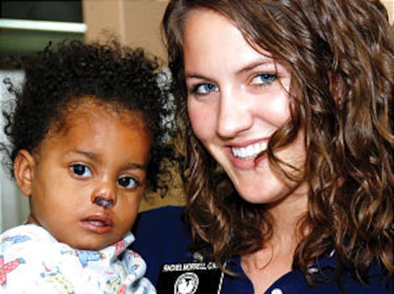 Rachel Morrell, the youngest volunteer of the group, holds a 15-month-old girl following surgical re