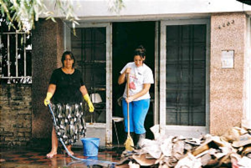 Church volunteers sanitize a flooded home after all the belongings, furniture were discarded. Only 3