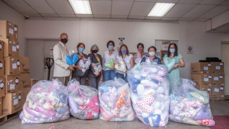 Latter-day Saints and members of the Puerto Rican League Against Cancer pose for a photo behind bags filled with heart pillows that were donated to help breast cancer patients recover from mastectomy surgery in December 2020.