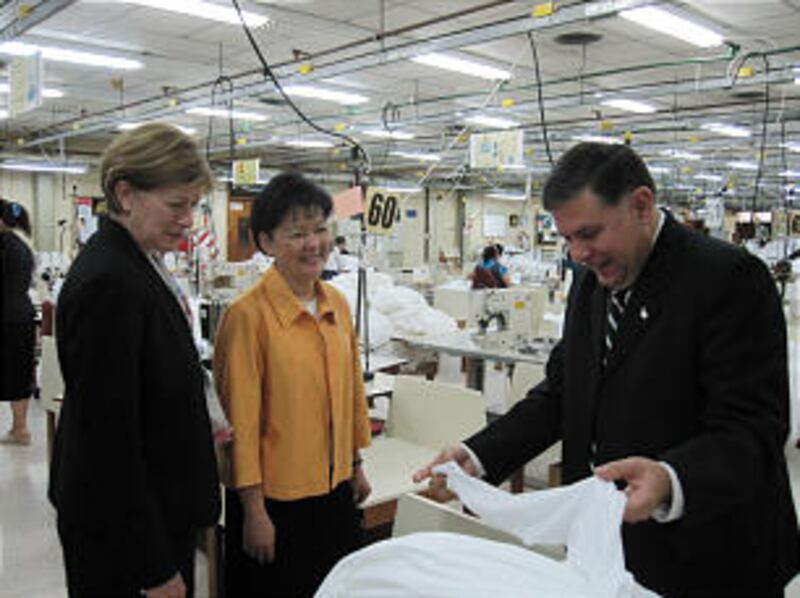 Juan Emilio Escobar Schaerer, director of Beehive Clothing in Asuncion, Paraguay, shows fabric to Si