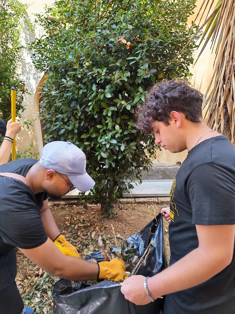 Volunteers from the Palermo Italy Stake collect leaves and yard debris while cleaning the grounds of Casa Scalabrini 634 in Rome, Italy.