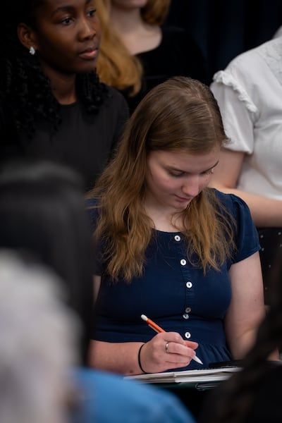 A young woman takes notes as Elder K. Brett Nattress, a General Authority Seventy, gives a devotional at Ensign College on Tuesday, March 24, 2026.