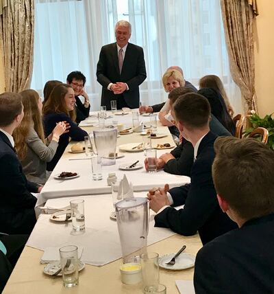Elder Dieter F. Uchtdorf of the Quorum of the Twelve Apostles, standing at center, and Sister Harriet Uchtdorf, at his right, join a going-away dinner for 8 volunteers from the Russia St. Petersburg Mission at the mission home on April 25, 2018, prior to their departure to return home the next morning.