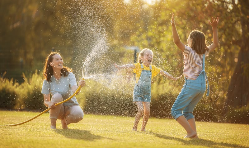 A mother plays outside with her daughters.