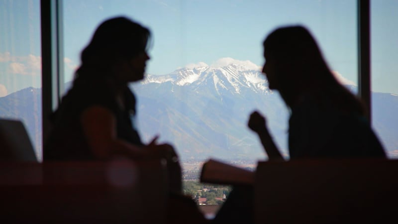 Missionaries visit with the Wasatch Mountains in the background during the filming of a new video at the Provo Missionary Training Center.
