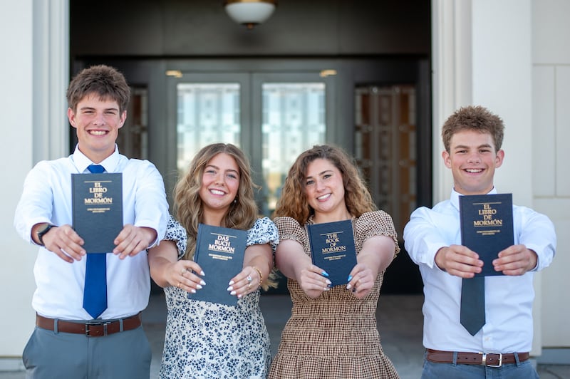 Siblings Eli, Elle, Isabel and Isaac Reid hold up copies of the Book of Mormon in the respective languages they will learn as missionaries.