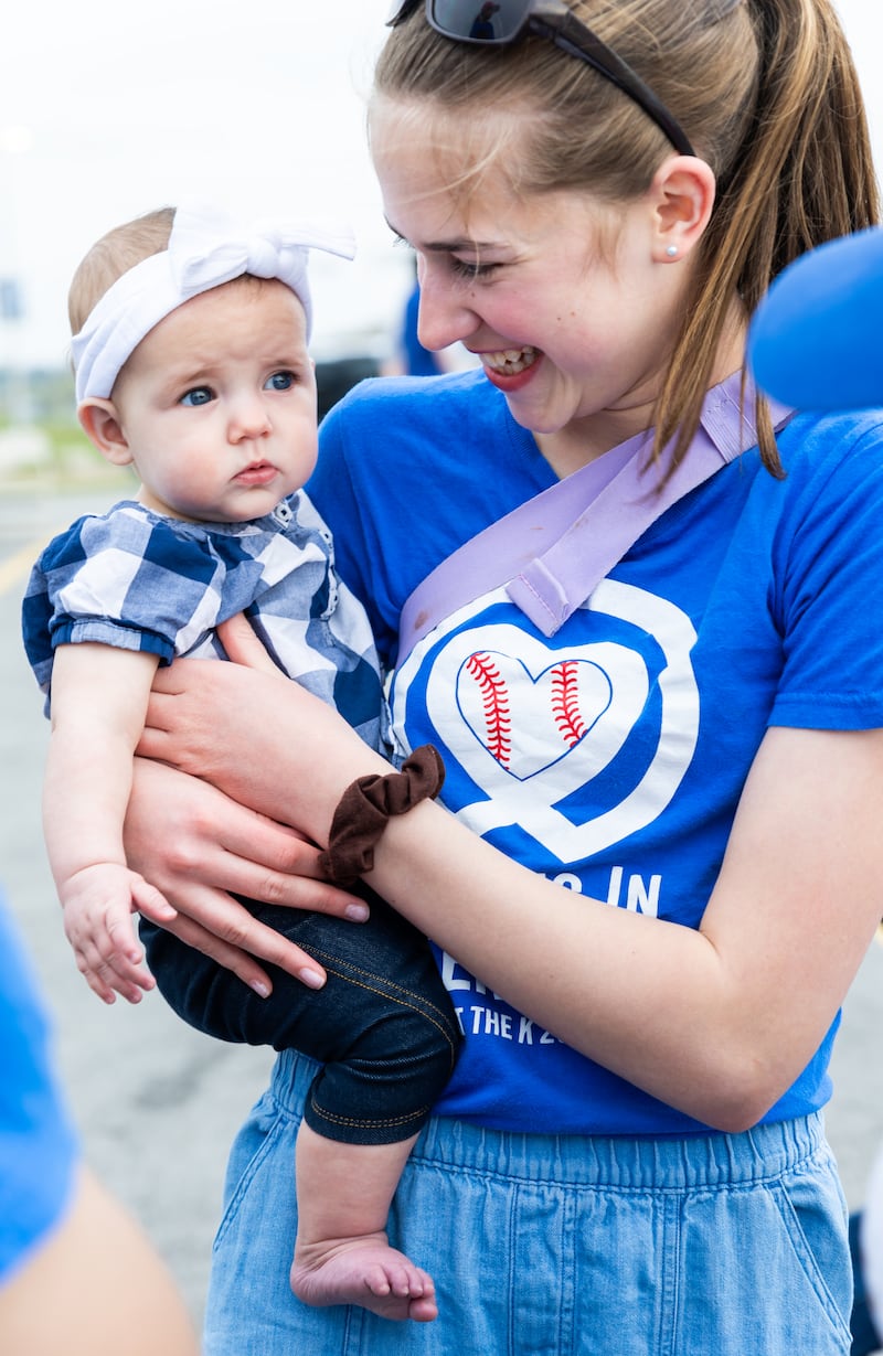 A volunteer pauses for a photo with her little sister at a JustServe night at the Kansas City Royals game in Kansas City, Missouri, on April 9, 2026.