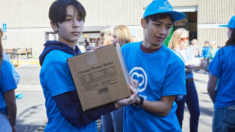 Two young men move boxes from an America250 food donation in the Irvine, California, area on Saturday, Feb. 21, 2026.