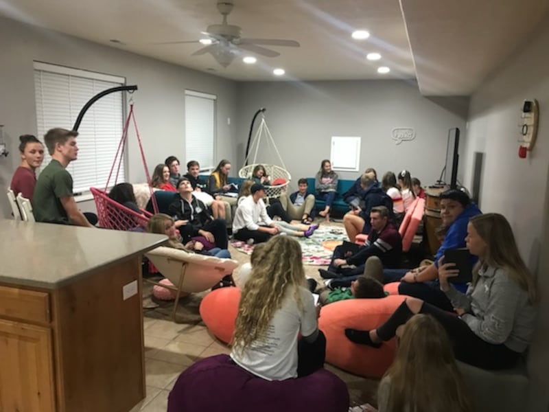 A crowd of teenagers enjoy studying the scriptures together in a weekly student-led scripture study group.