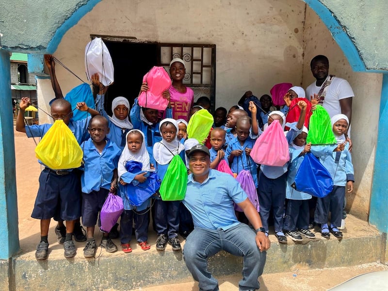 Konrad Barjuah, center, delivers school kits to a school in Liberia.