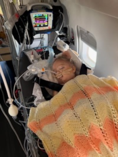 Estelle Santiago, then 3 years old, lies comatose during a medical flight out of Uruguay in January 2026.