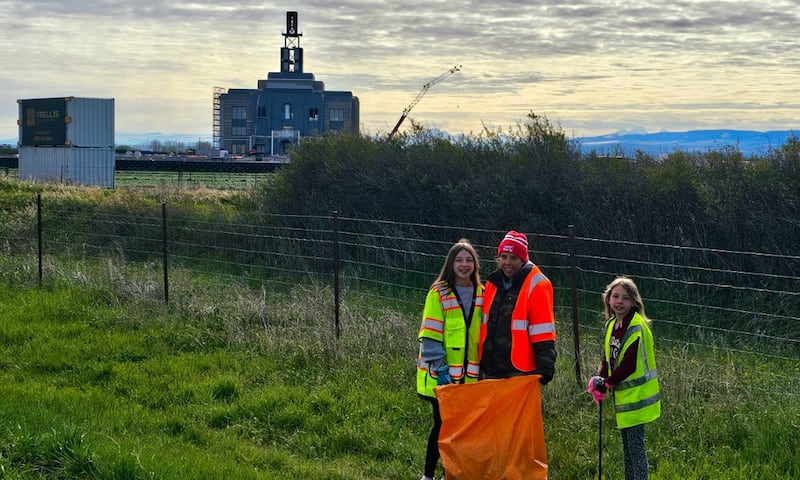 Young women gather trash along the highway near Rexburg, Idaho, as part of Global Youth Service Day on Saturday, April 25, 2026. The Teton River Idaho Temple is under construction in the background.