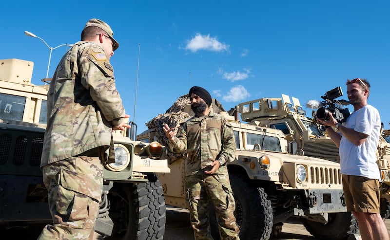 U.S. Army Lt. Col. Simratpal “Simmer” Singh speaks with a fellow soldier during the filming of a "Voices for Faith" episode.