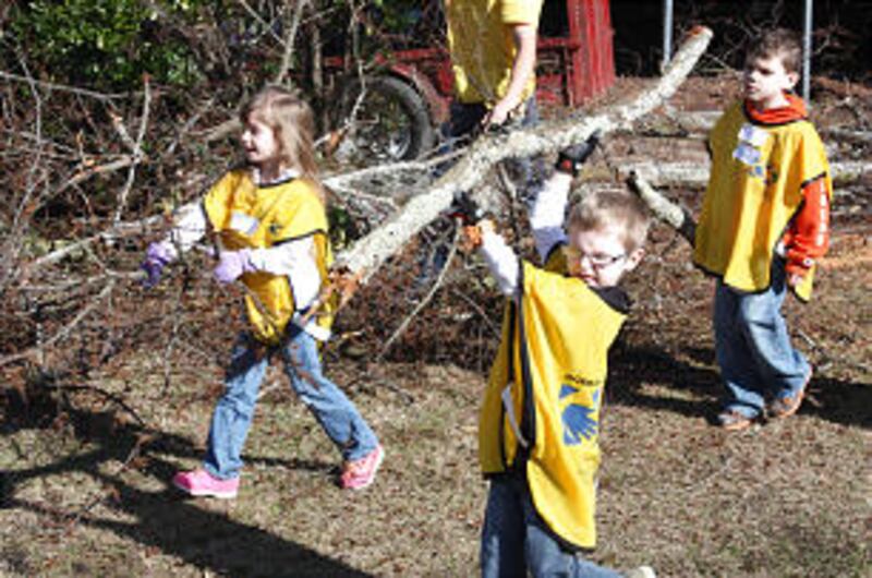 Kaylee Weatherman (left), 6, Coleman Evans (right), 7, and Henry Lines (back), 8 help clean up stor