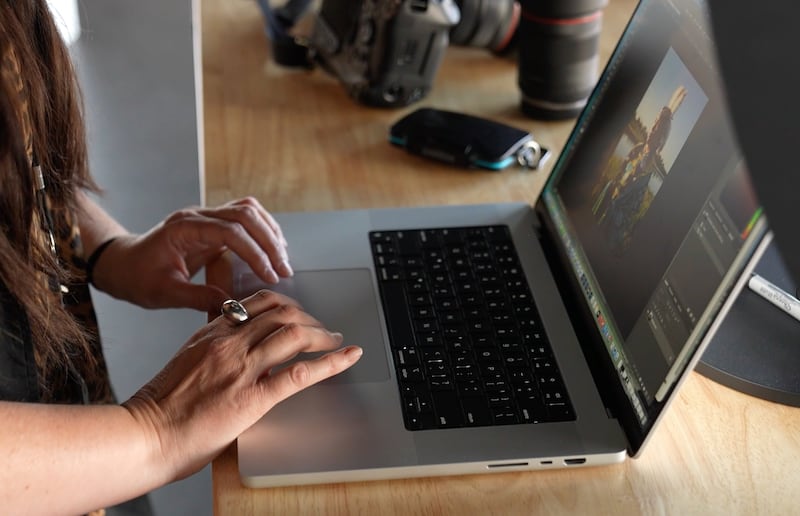 Church photographer Tina Smith sorts and edits photos on her laptop.