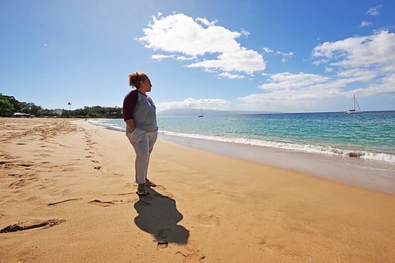 Etina Hingano stands on the beach by the water and looks out near Lahaina, Hawaii, on the island of Maui.