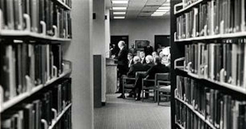 Framed by genealogical volumes in stacks on main level, President Gordon B. Hinckley addresses 185 g