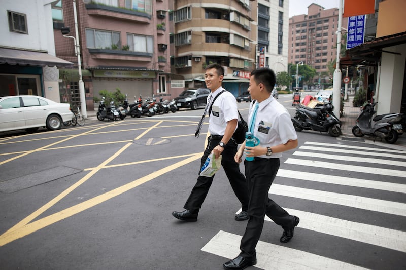 A pair of full-time missionaries cross the street in Taiwan in 2025.