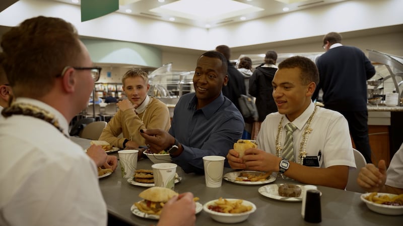 Missionaries speak with video host Danor Gerald while eating in the cafeteria at the Provo Missionary Training Center.