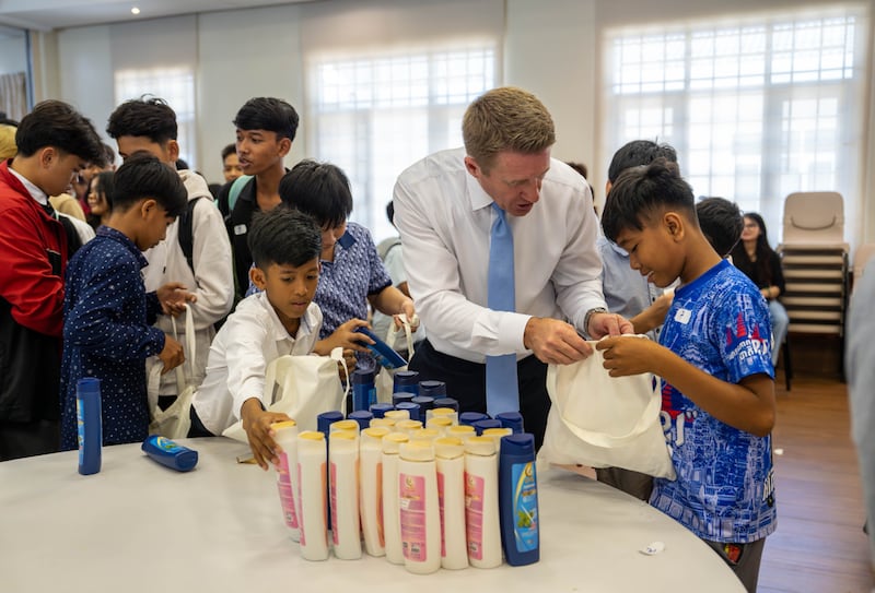 Young Men General President Timothy L. Farnes assists a youth during a service project to assemble more than 200 care bags for an orphanage in Phnom Penh, Cambodia in May 2026.