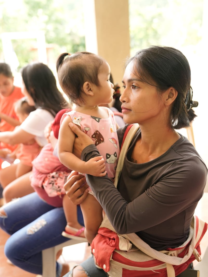 A mother and child attend a nutritional screening in the Philippines, August 2025.