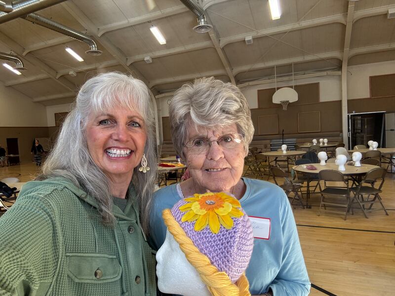 Members of the Blanding, Utah, community snap a photo with a wig made for children undergoing cancer treatments on Oct. 25, 2025, in Blanding.
